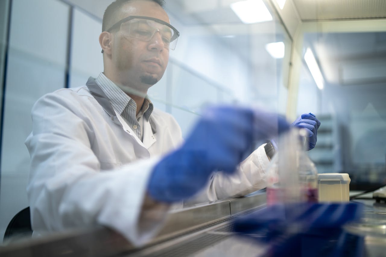A scientist conducts research in a lab using protective equipment.